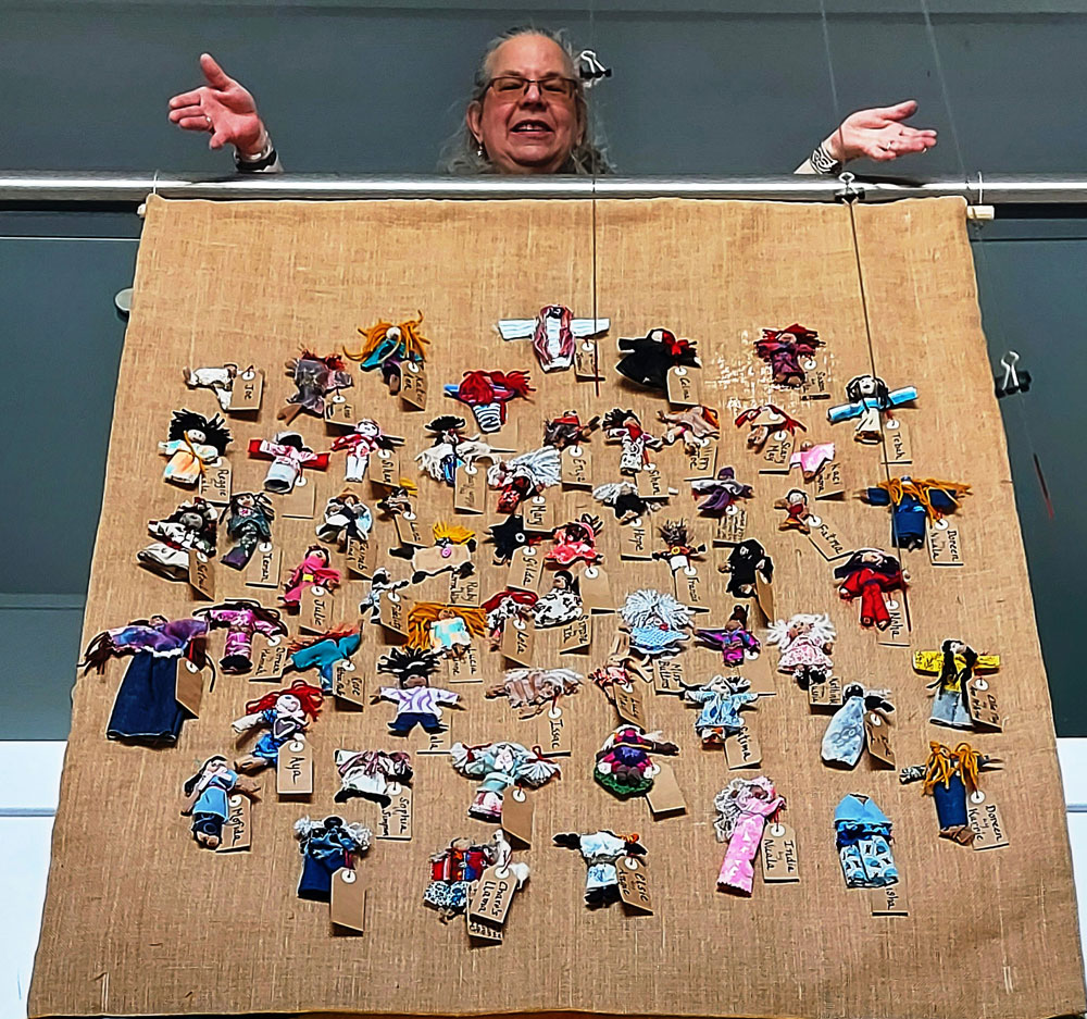 Workshop facilitator Deborah Stockdale with the finished collective banner; the outcome of workshops with six groups responding to the theme of Refugee week 2021 