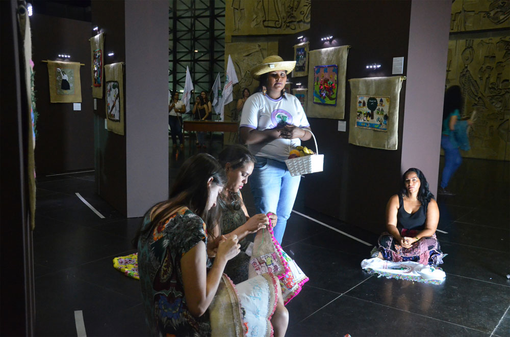 Performance by women from Movimento dos Atingidos por Barragens (MAB)at the exhibition:'Arpilleras Bordando à Resistência / Arpilleras Embroidering Resistance', (Photo: Diego Souza Carlos)